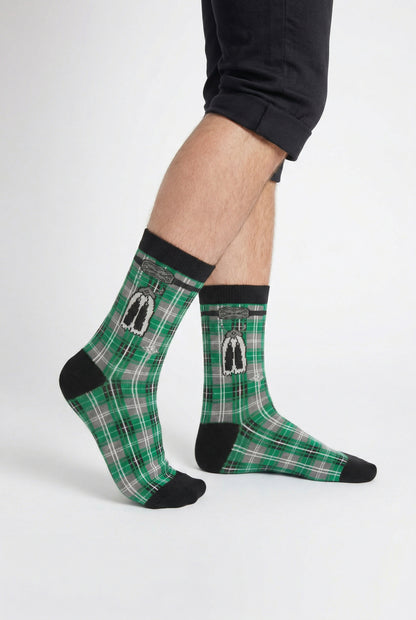 Green tartan socks with black accents worn by a person on a white background