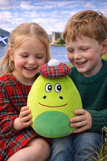 Two children holding a green plush Nessie soft toy wearing a red tartan hat.