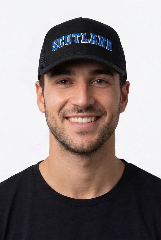 Man wearing a black cap with 'Scotland' text on a white background