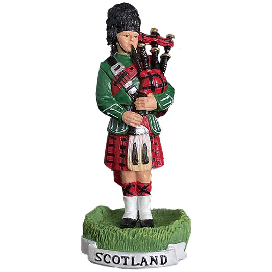 Statue of a bagpiper in Scottish attire with 'Scotland' on a white background.